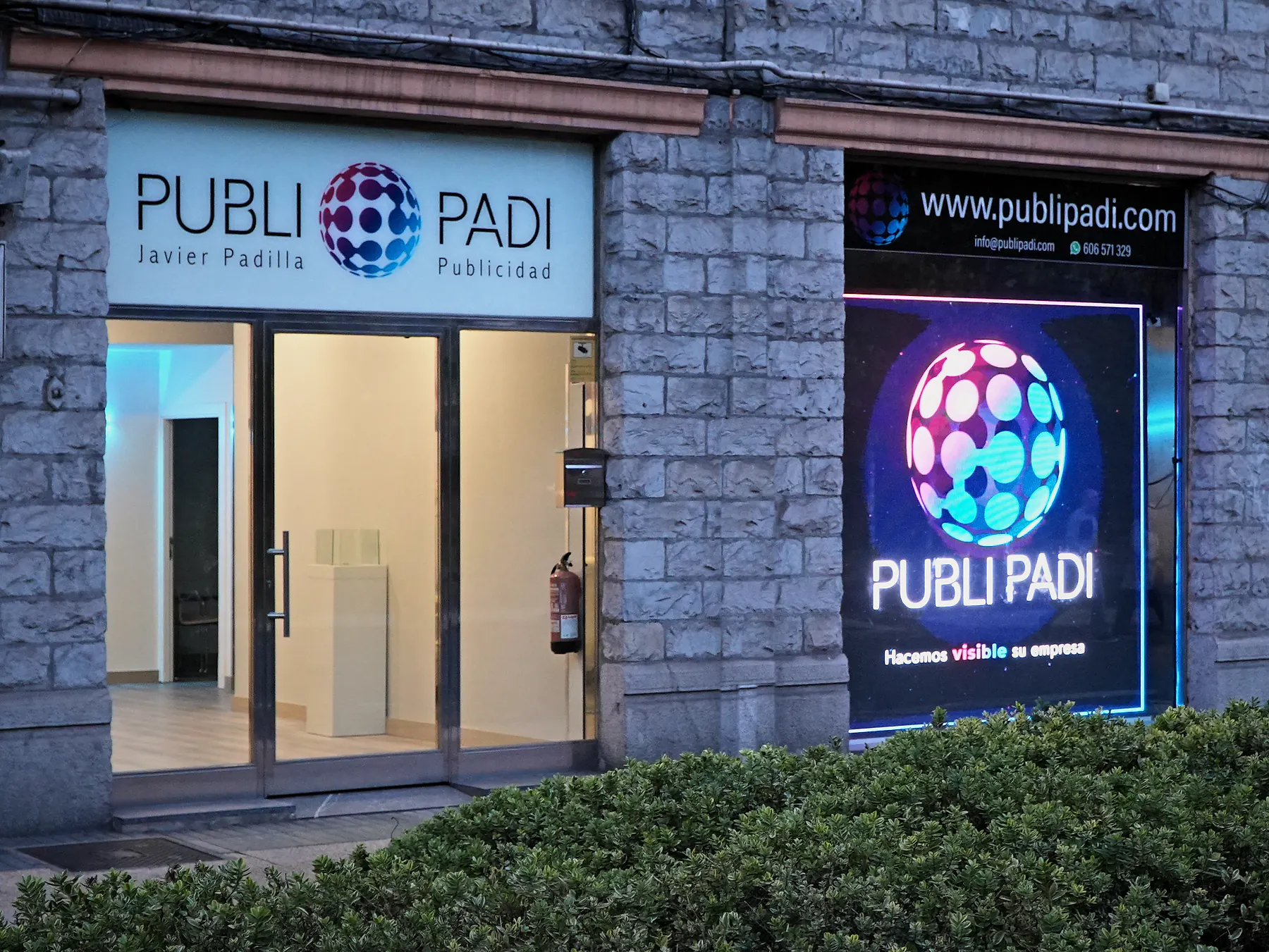 Local de Publipadi con su pantalla LED encendida al anochecer en el centro de Vitoria-Gasteiz